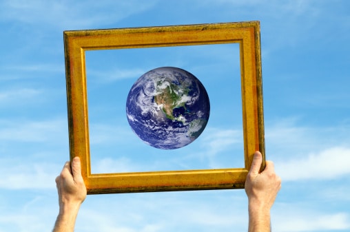 Hands Holding Earth in Frame against Blue Sky signifying online art class opens world of opportunities.