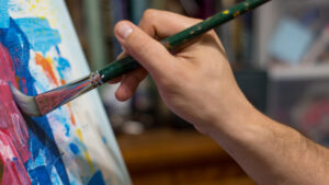 Closeup of man`s hand painting an acrylic or oil abstract picture-Yarnell School Online