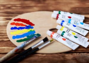 Wooden art palette with tubes of oil paints and a brush. Acrylics for Underpainting - Yarnell School Online